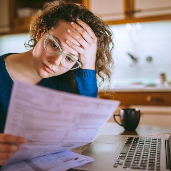 woman appearing stressed looking at paperwork